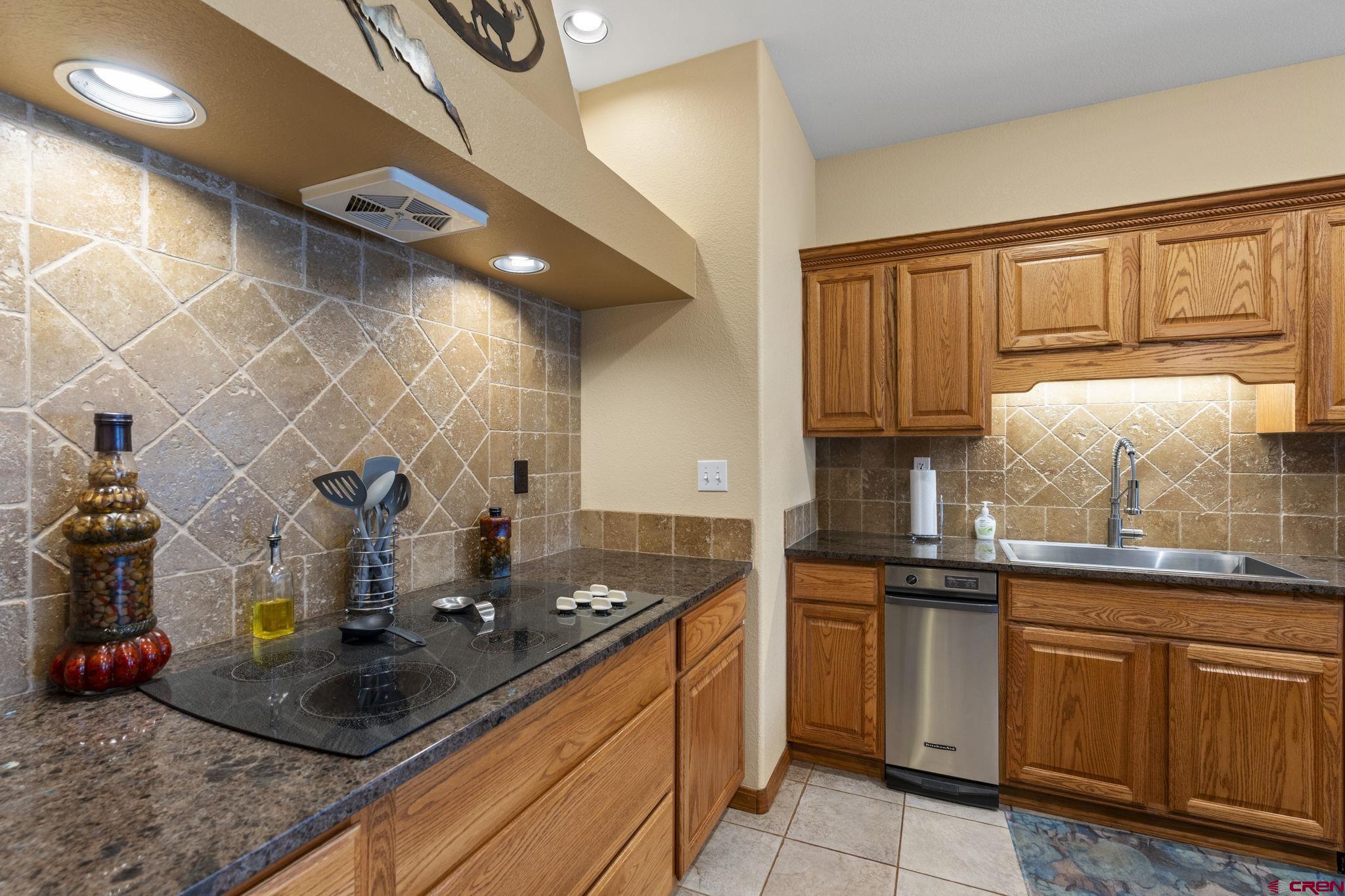 33140 Highway 550 Durango, CO 81301 - Photo 19 of 38 a kitchen with granite countertop a sink dishwasher stove and cabinets