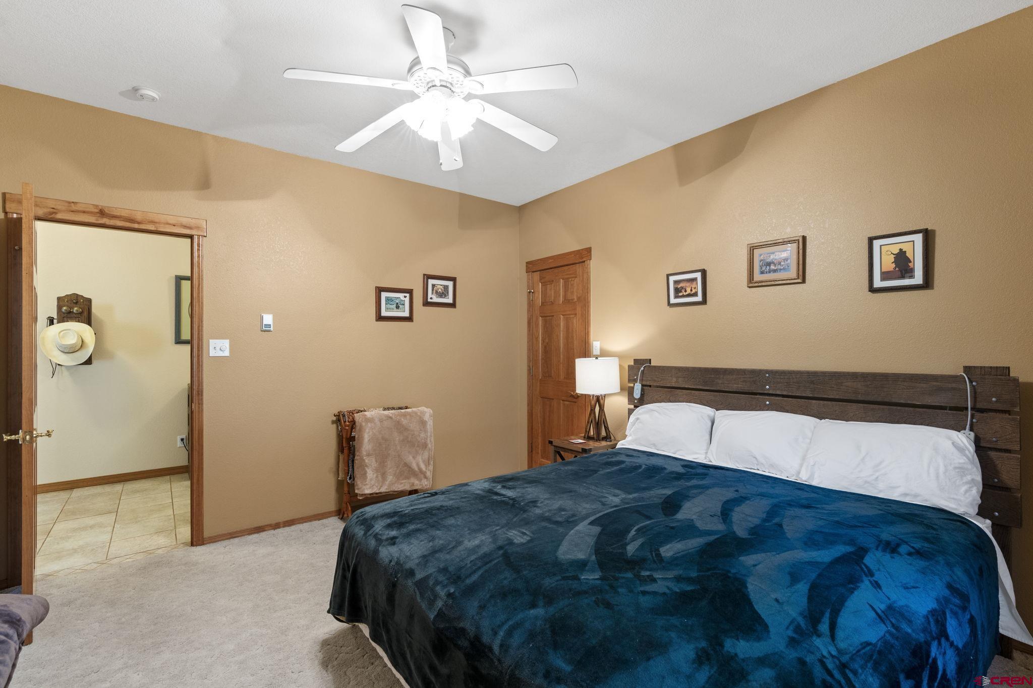 33140 Highway 550 Durango, CO 81301 - Photo 25 of 38 a bedroom with a large bed and a chandelier