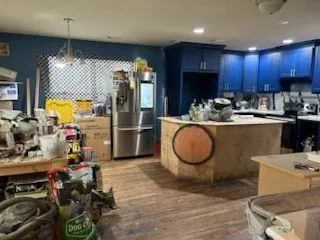 a kitchen with refrigerator and chairs