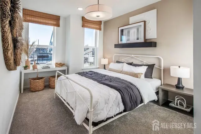 a bedroom with a bed a large window and potted plant