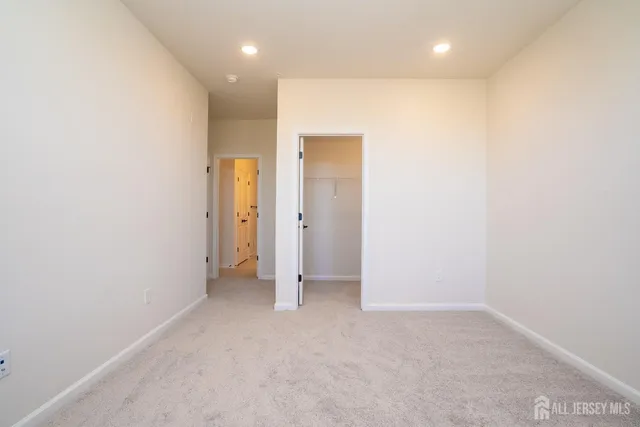 an empty room with a bathroom and a hallway