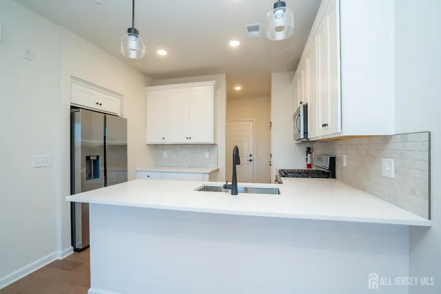 a kitchen with kitchen island a sink stainless steel appliances and cabinets