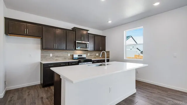 a kitchen with a sink a stove a microwave and cabinets