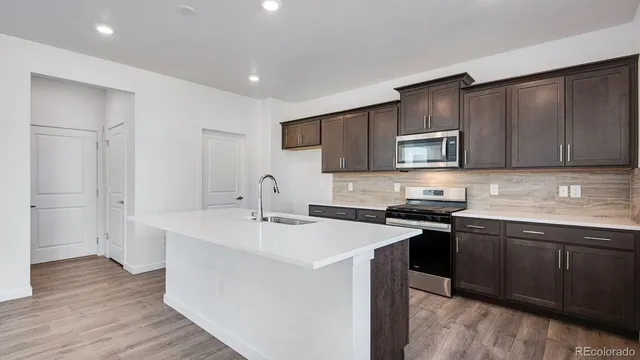 a kitchen with a sink cabinets and wooden floor