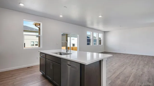 a kitchen with a sink granite counter tops and a window