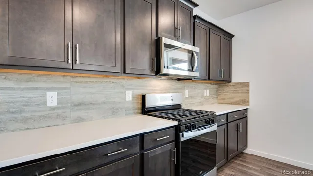 a kitchen with stainless steel appliances a sink stove and cabinets