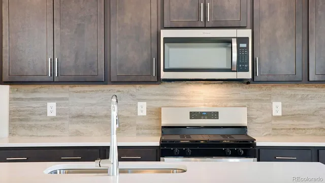 a kitchen with granite countertop a stove and a microwave