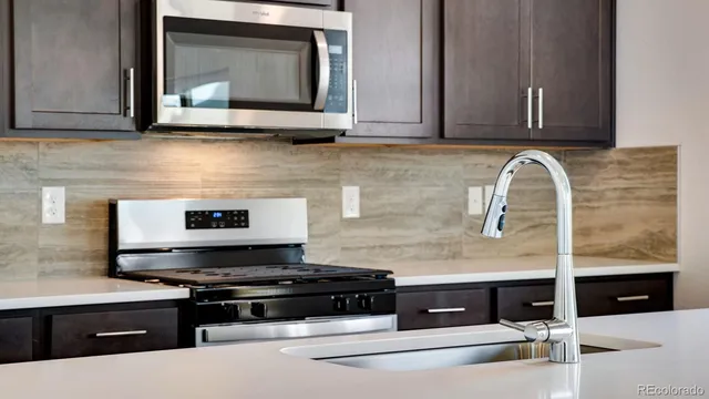 a kitchen with stainless steel appliances granite countertop a stove and a microwave