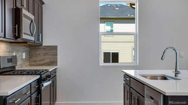 a kitchen with a sink stove top oven and cabinets
