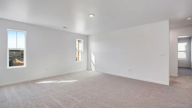 an empty room with windows and closet