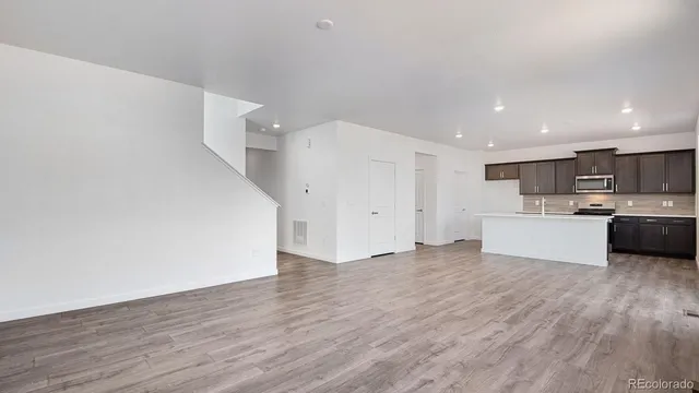 a view of kitchen with wooden floor and electronic appliances
