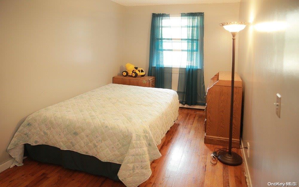 610 Pine Street Brooklyn, NY 11208 - Photo 14 of 35 a bed sitting in a bedroom next to a window and a chandelier