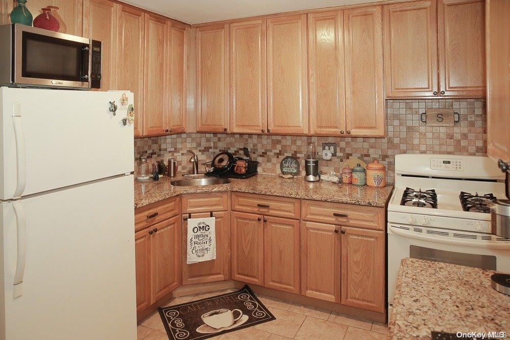 610 Pine Street Brooklyn, NY 11208 - Photo 24 of 35 a kitchen with a refrigerator sink and white cabinets