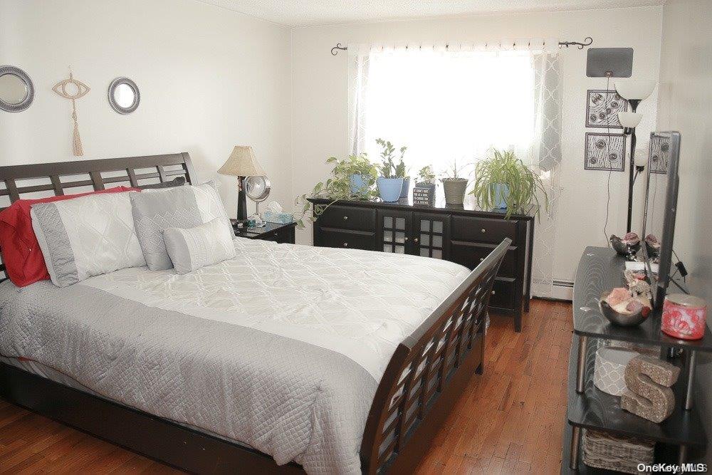 610 Pine Street Brooklyn, NY 11208 - Photo 6 of 35 a bedroom with a bed a dresser and potted plants