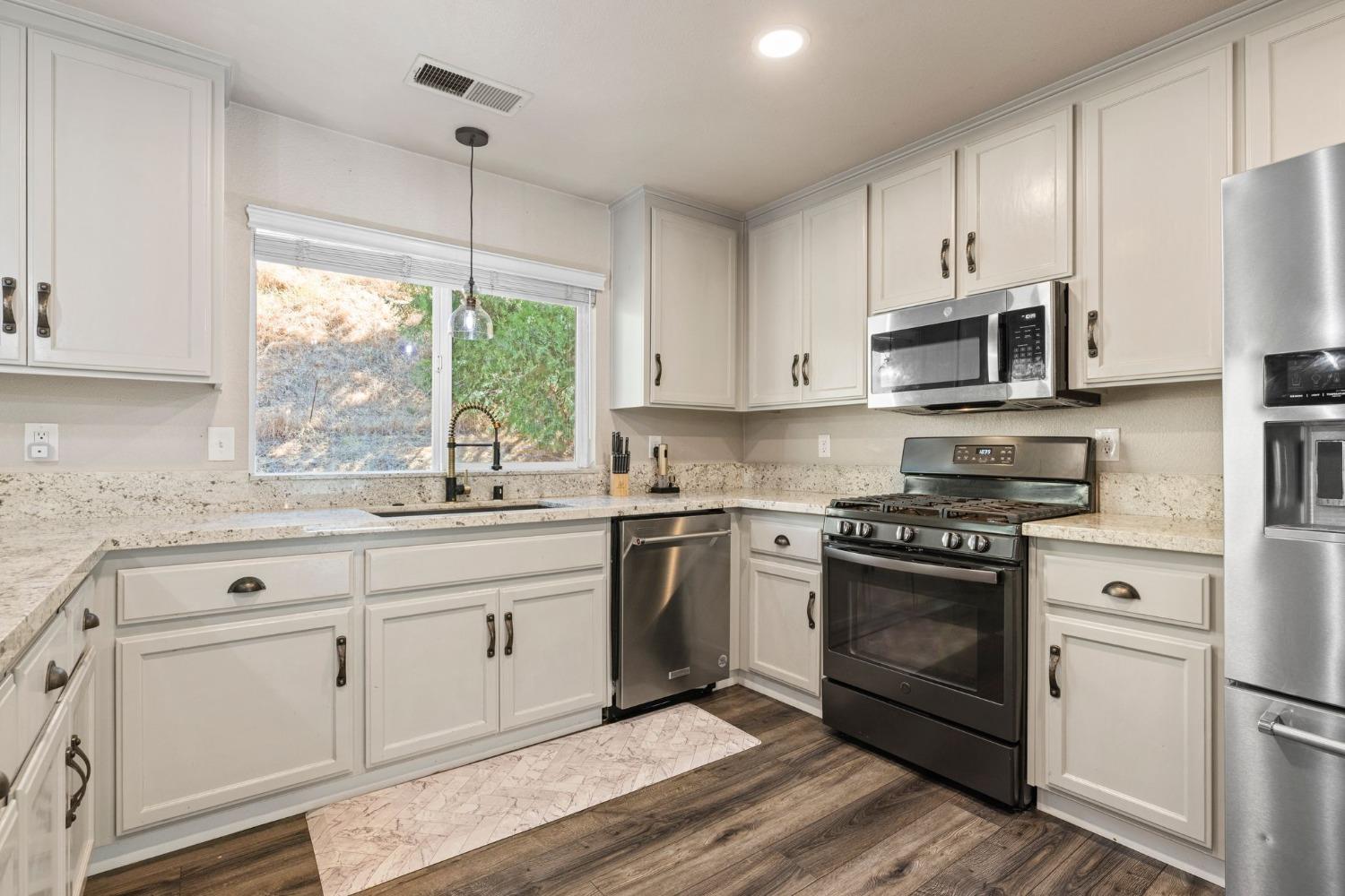 4842 Northern Lights Road Placerville, CA 95667 - Photo 9 of 26 a kitchen with white cabinets appliances a sink and a window