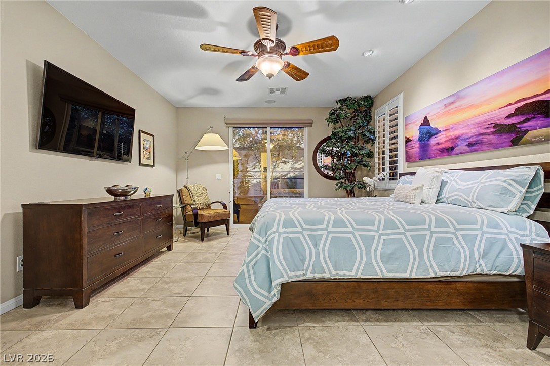 7415 Campbell Ranch Avenue Las Vegas, NV 89179 - Photo 28 of 52 Relax in this tranquil bedroom, featuring a large sliding glass door, tiled floors, and a beautiful ceiling fan.