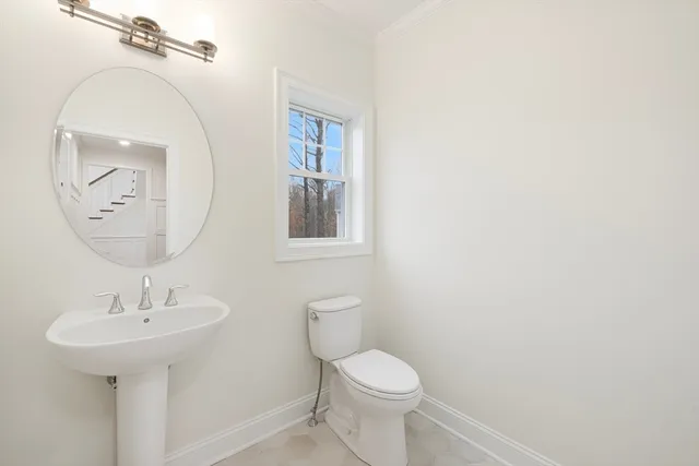 a bathroom with a toilet a sink and mirror