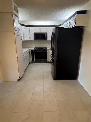 a kitchen with a refrigerator and a counter top space