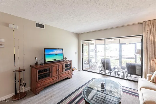 a living room with furniture a flat screen tv and a large window
