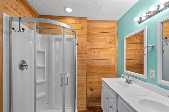 a bathroom with a sink vanity granite shower and a mirror