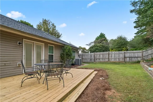a view of a backyard with chairs potted plants and wooden fence
