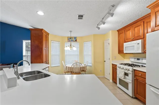 a kitchen with stainless steel appliances a sink stove and cabinets