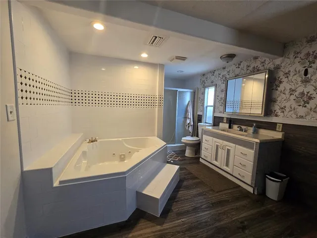 a spacious bathroom with a tub double vanity sink and a mirror