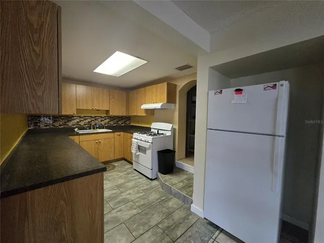 a kitchen with a refrigerator a stove top oven a sink and dishwasher