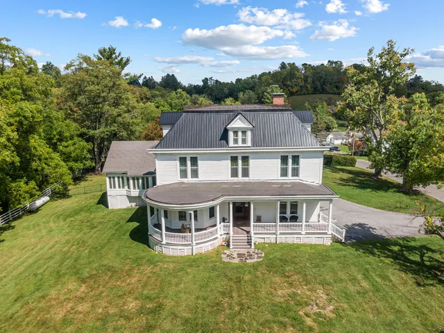 a aerial view of a house with a yard table and chairs