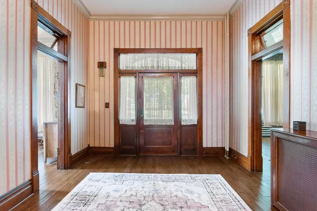 a view of a hallway with wooden floor and windows