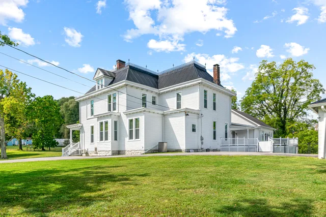 a aerial view of a house with a yard and table and chairs