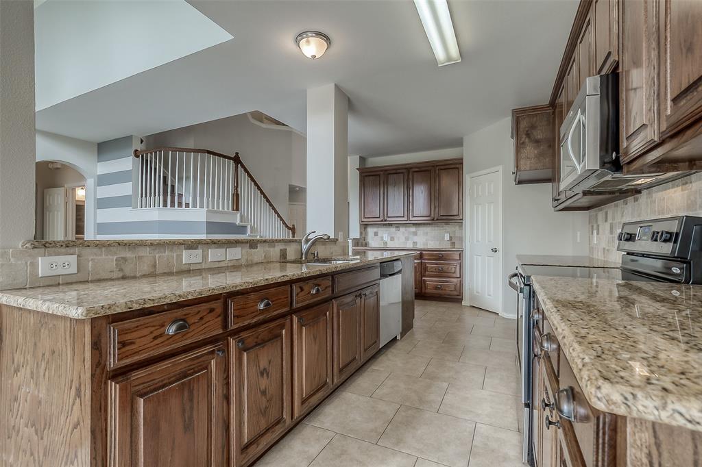 3100 Crossridge Drive McKinney, TX 75071 - Photo 11 of 40 a kitchen with stainless steel appliances granite countertop a sink and a stove
