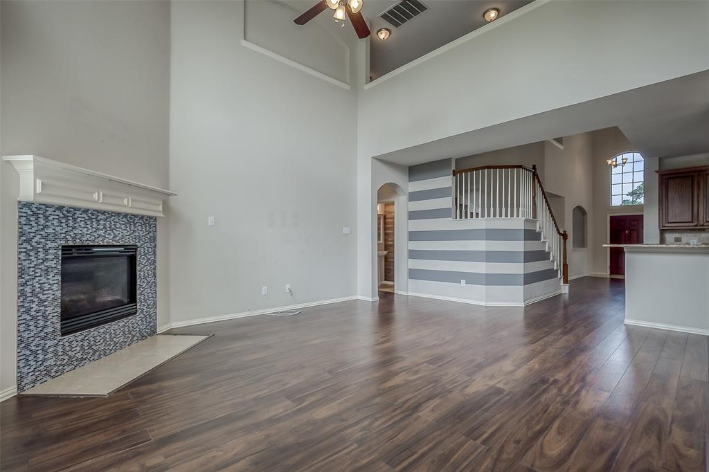 3100 Crossridge Drive McKinney, TX 75071 - Photo 14 of 40 a view of a hallway with wooden floor a chandelier and a fireplace