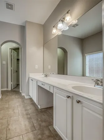 a spacious bathroom with a double vanity sink and a mirror
