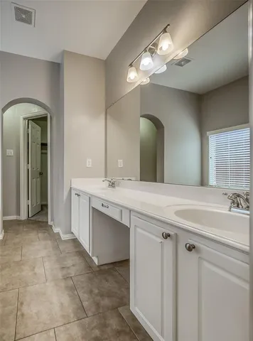 a spacious bathroom with a double vanity sink and a mirror