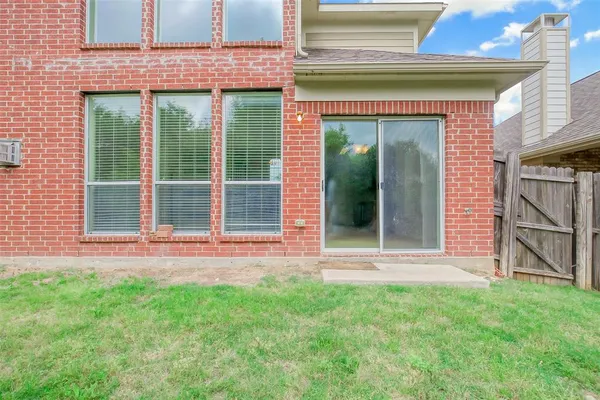 a view of a backyard with table and chairs and wooden fence