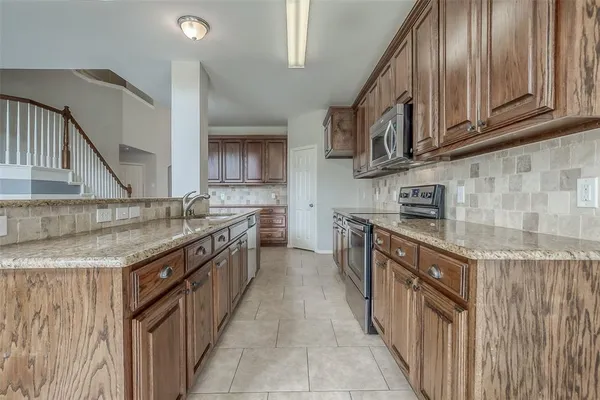 a kitchen with stainless steel appliances granite countertop a sink and cabinets
