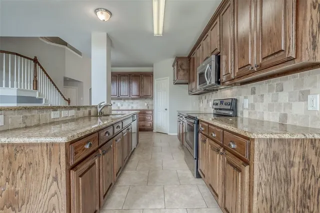 a kitchen with stainless steel appliances granite countertop a sink and cabinets