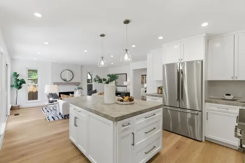 a kitchen with stainless steel appliances granite countertop a refrigerator a sink and a stove
