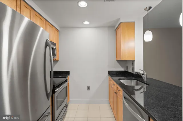 a kitchen with stainless steel appliances wooden cabinets and a stove top oven