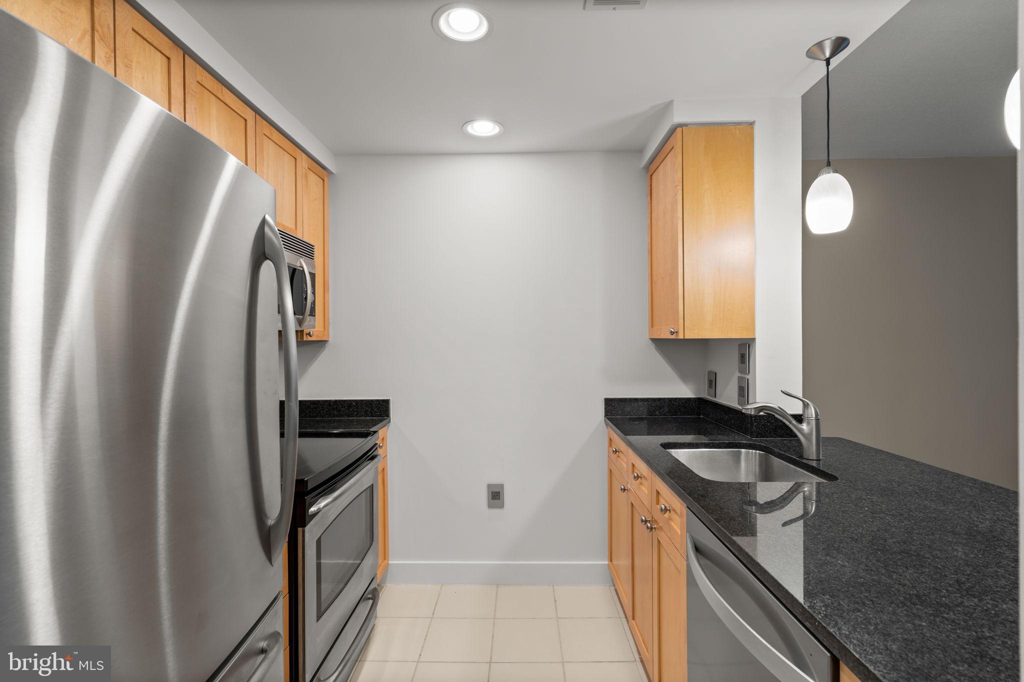 2001 15th Street North, Unit 813 Arlington, VA 22201 - Photo 11 of 31 a kitchen with granite countertop a refrigerator stove and sink