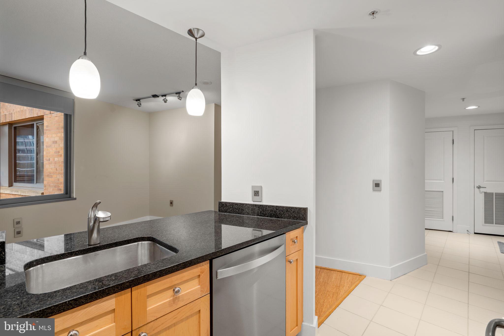 2001 15th Street North, Unit 813 Arlington, VA 22201 - Photo 13 of 31 a kitchen that has a sink and a granite counter top