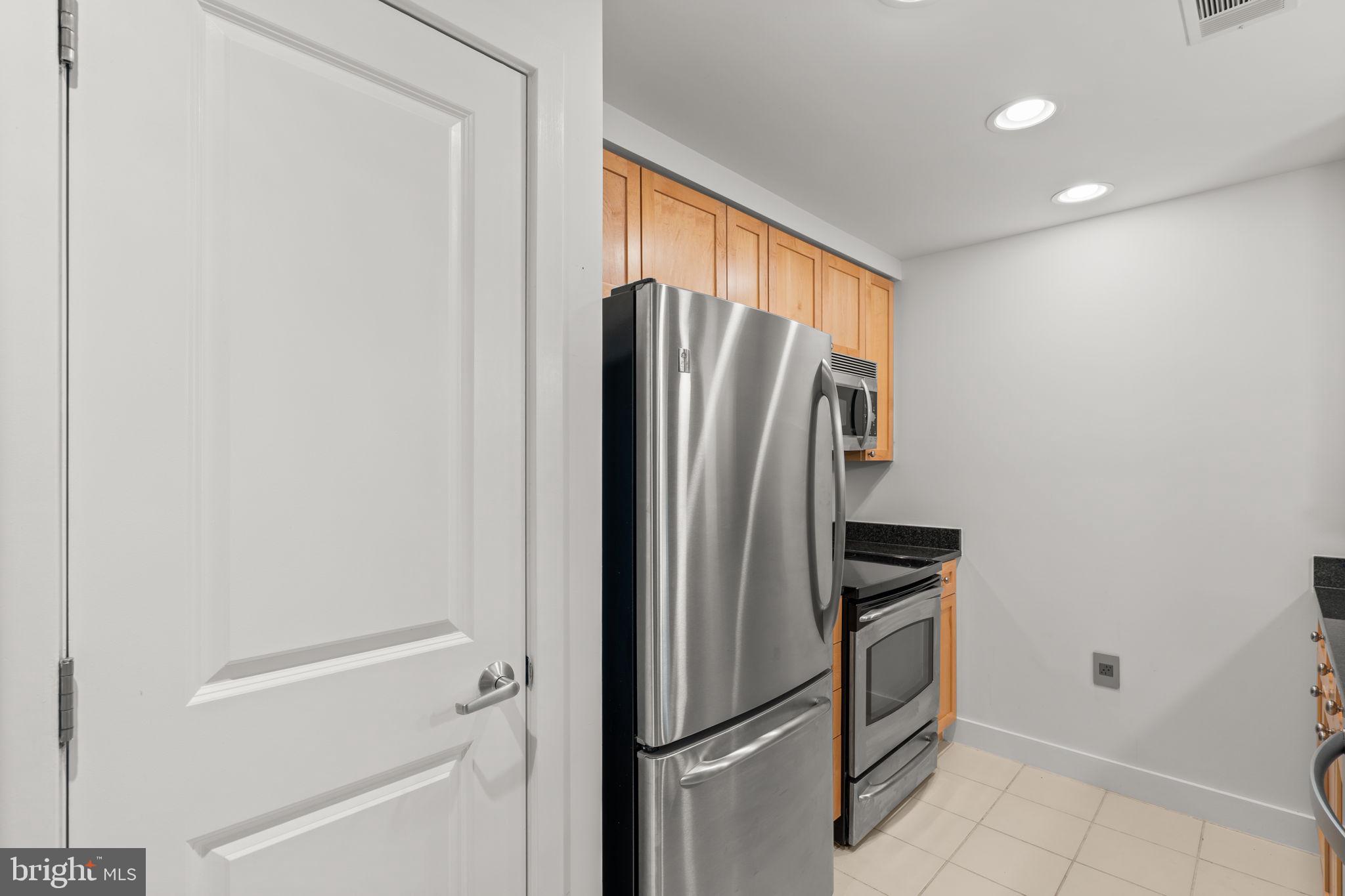 2001 15th Street North, Unit 813 Arlington, VA 22201 - Photo 14 of 31 a metallic refrigerator freezer sitting in a kitchen