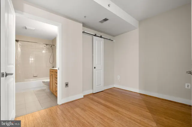 an empty room with wooden floor and closet area
