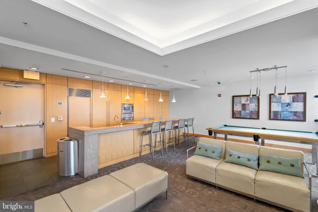 a dining hall with stainless steel appliances granite countertop a kitchen island a table and chairs