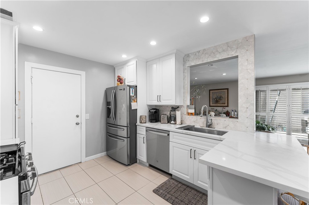 12331 Carl Street Pacoima, CA 91331 - Photo 11 of 28 a kitchen with white cabinets and stainless steel appliances