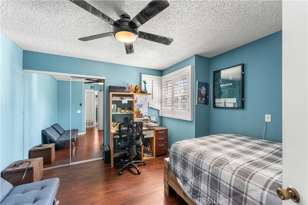 12331 Carl Street Pacoima, CA 91331 - Photo 21 of 28 a bedroom with a bed a desk and chair with wooden floor