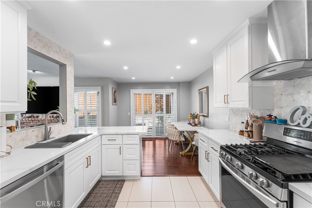 12331 Carl Street Pacoima, CA 91331 - Photo 10 of 28 a large kitchen with stainless steel appliances a stove a sink dishwasher and cabinets with wooden floor