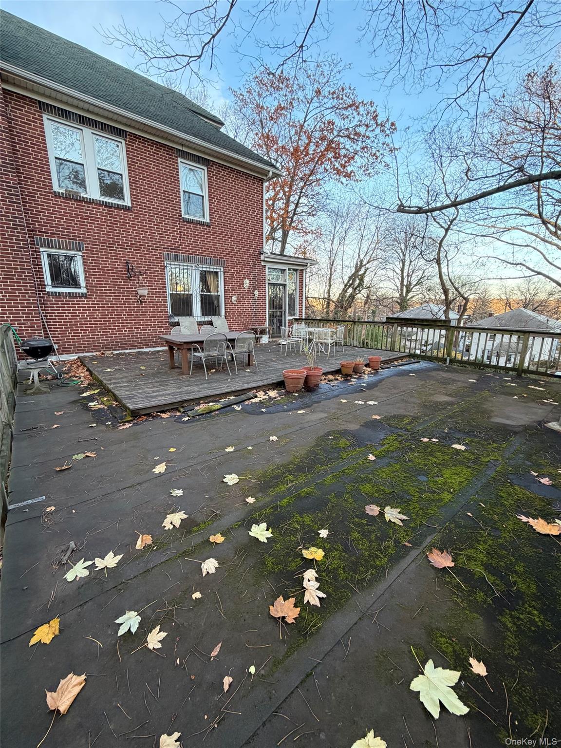 6004 Netherland Avenue Bronx, NY 10471 - Photo 6 of 30 a backyard of a house with table and chairs and a large tree