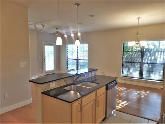 a kitchen that has a sink and a view of dining room